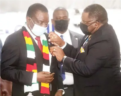  ?? ?? President Mnangagwa is conferred with honorary Rotarian membership by Rotary Internatio­nal director-elect Mr Patrick Chisanga at the official opening of the Rotary Internatio­nal District 9210 Conference at Manna Resorts in Harare last night. — Picture: Believe Nyakudjara
