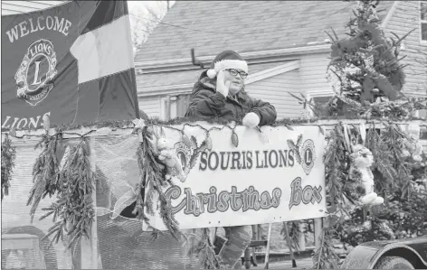  ?? KATHERINE HUNT/THE GUARDIAN ?? Volunteer Mariah Laybolt waves to the crowd while on the Souris Lions Club’s float during the Souris Christmas Parade. The parade entry promoted the club’s annual Christmas Box program, which provides the essentials for families and individual­s in the community who need assistance during the holidays.