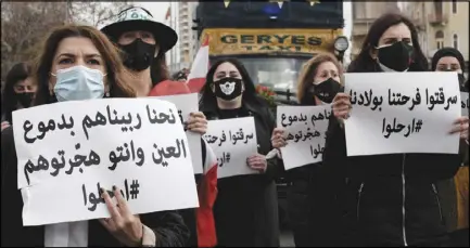  ??  ?? أمهات وناشطات يحملن ملصقات تطالب المسؤولين اللبنانيين بالرحيل