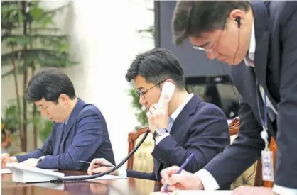  ?? Associated Press ?? An official from South Korean President Blue House talks on the phone with North Korea side for a hotline test in Seoul on Friday.