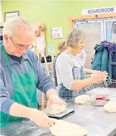  ?? ?? Gary Farrah (left) shapes dough into loaves with another volunteer, Elva Hawkins, on Monday.