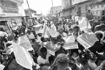  ??  ?? Supporters of presidenti­al candidate Maryse Narcisse, of Fanmi Lavalas party, hold posters during a protest in Port-au-Prince, Haiti. — Reuters photo