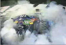 ?? GETTY IMAGES/SARAH CRABILL] [NASCAR ?? Kyle Busch creates a ring of tire smoke after winning Saturday night’s All-Star Race at Charlotte.