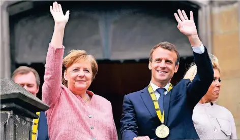  ?? FOTO: IMAGO ?? Kanzlerin Merkel und Frankreich­s Präsident Emmanuel Macron mit Ehefrau Brigitte am Donnerstag auf dem Balkon des Aachener Rathauses.