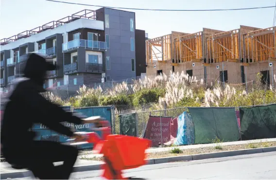  ?? Photos by Santiago Mejia / The Chronicle ?? A man rides past the site where a radioactiv­e deck marker was found near Donahue Street and Galvez Avenue at the former Hunters Point Naval Shipyard.