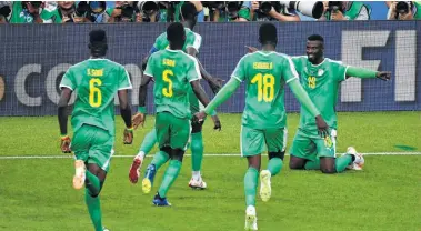  ?? Alexander Nemenov / AFP/ Getty Images ?? Senegal forward Mbaye Niang (right) celebrates after scoring his team’s second goal in a victory overPoland on Tuesday. Senegal and Japan are tied for the Group H lead.