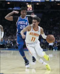  ?? CHRIS SZAGOLA – THE ASSOCIATED PRESS ?? Atlanta’s Trae Young, right, pushes the ball toward the basket Monday night against Sixers guard Markelle Fultz at Wells Fargo Center.