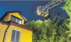 ?? FOTO: CHRISTIAN FLEMMING ?? Die Lindauer Feuerwehr inspiziert das Dach eines Hauses, auf das ein Nussbaum vom Nachbargru­ndstück gestürzt ist.