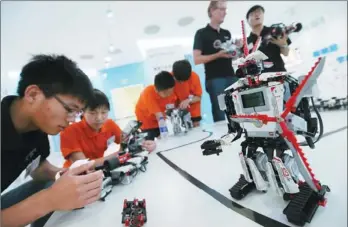  ?? PROVIDED TO CHINA DAILY ?? Students show interest in the robot series, EV3, produced by Lego, the largest educationa­l robot provider in China at the toy’s launching ceremony.