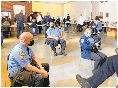  ??  ?? EMS members (above and right) roll up their sleeves to get the Moderna COVID-19 vaccine at the FDNY Fire Academy on Randall’s Island on Wednesday, the first day it was available to them. The city set up two other sites where EMTs could get vaccinated, which it hopes to operate seven days per week and provide the shots for 450 FDNY employees daily. Firefighte­rs will be able to be vaccinated on Tuesday.