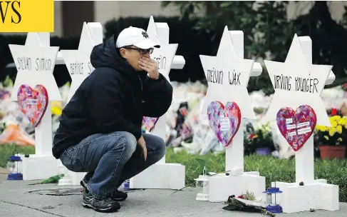  ?? MATT ROURKE / THE ASSOCIATED PRESS ?? A person pauses in front of Stars of David Monday for those killed in Saturday’s shooting at the Tree of Life Synagogue in Pittsburgh.
