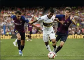  ?? MANU FERNANDEZ — THE ASSOCIATED PRESS ?? FC Barcelona’s Munir El Haddadi, left, and Juan Miranda, right, vie for the ball against Boca Juniors’ Wilmar Barrios during the Joan Gamper trophy friendly soccer match between FC Barcelona and Boca Juniors at the Camp Nou stadium in Barcelona, Spain, Wednesday.