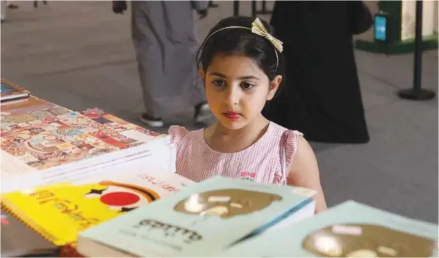  ?? ?? ↑
A young book lover scans the literature on display.