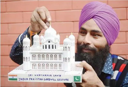  ?? Agence France-presse ?? Artist Gurmeet Singh poses with a paper model of the Gurdwara Kartarpur Sahib in Amritsar on Wednesday. Hyderabad:indiawon’tattendthe