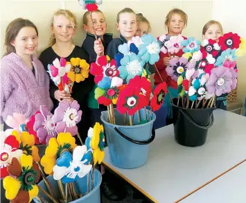  ?? ?? Poowong Consolidat­ed School students Liv, Imogen, Alfie, Amy, Macey, Willow, Tess and Melody show off the bright and colourful felt flowers they created to mark the 50th celebratio­ns.