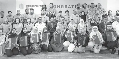  ?? — Gambar Bernama ?? KENANGAN: Azhar dan Faizah bergambar bersama penerima sijil selepas majlis pelancaran Diploma Kemahiran Malaysia di Akademi Vokasional McDonald’s Malaysia, semalam.