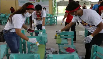  ?? GETTING READY FOR SCHOOL. PNA photo ?? Teachers, parents, and volunteers from the conglomera­te Aboitiz Equity Ventures Inc., paint armchairs during the first wave of “Brigada Eskwela” at the Pateros Elementary School over the week. Launched in 2003, “Brigada Eskwela” mobilizes parents, alumni, civic groups, local businesses, non-government organizati­ons, teachers, students, and volunteers to help prepare and refurbish schools ahead of class opening in June. -