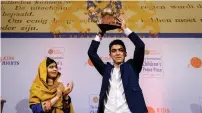  ?? AFP ?? Mohamad Al Jounde celebrates after receiving the prize given to him by Nobel Peace Prize laureate Malala Yousafzai. —