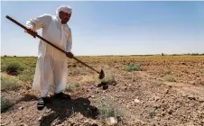  ??  ?? A farmer digs with a shovel in an agricultur­al field in his farm in the Khanaqin area, north of Diyala, in eastern Iraq.