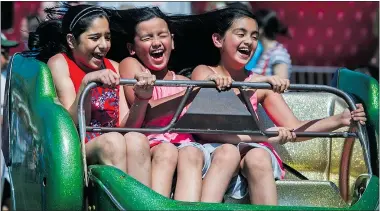  ??  ?? Priya Jhajj, left, and twin sisters Sareena, centre, and Simran Heran enjoy one of the many amusement rides during last year’s Canada Day celebratio­ns in Surrey.
