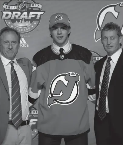  ?? The Associated Press ?? CHOSEN ONE: Nico Hischier wears a New Jersey Devils jersey after being selected first overall by the team during the NHL draft Friday night in Chicago. Hischier became the first Swiss player to be drafted with the first pick.