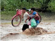  ?? REUTERS ?? People cross a river flooded by heavy rains brought by Nate in Nandaime, Nicaragua.