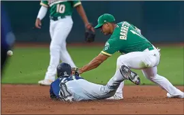  ??  ?? The Mariners’ Austin Nola slides into second base in front of the A’s Franklin Barreto.