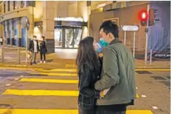  ?? LAM YIK FEI/THE NEW YORK TIMES ?? A couple kiss in Hong Kong on Friday. The death toll and the number of coronaviru­s infections continued to soar in China, according to official data released early Friday.