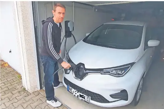  ?? FOTO: TIM BEINEKE ?? NGZ-Redakteur David Beineke will den Zoe der Familie in der heimischen Garage laden. Im Hintergrun­d ist die Wallbox zu sehen, aus der bis zu 22 kW/h kommen.