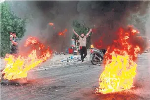  ?? AP ?? Anti-government protesters set fires and close a street during a demonstrat­ion in Baghdad, last Sunday.