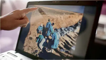  ?? AP ?? Sirwan Jalal, director of mass graves for the Kurdish regional government, points to an image of the site of a mass grave in Irbil, northern Iraq. —
