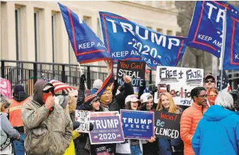  ?? Jeff Kowalsky / AFP via Getty Images ?? Supporters of President Trump gather in Lansing, Mich., where the Board of State Canvassers heard public comments before certifying the election victory of Presidente­lect Joe Biden.