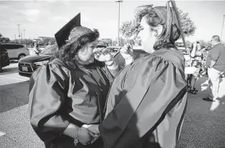 ?? Kin Man Hui / Staff photograph­er ?? Rebecca Garcia wipes away tears as she and her daughter Monica wait to start Northwest Vista College’s drive-thru graduation ceremony Friday, when they both earned their associate degrees.