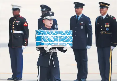  ?? KIM HONG-JI/AFP/GETTY IMAGES ?? A soldier carries the remains of a U.S. soldier killed in the 1950-53 Korean War during a repatriati­on service on Friday.