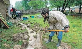  ?? Robert Gourley For The Times ?? IN FAYETTEVIL­LE, N.C., Brandon Cuthrell helps his brother Kenneth Stevenson, background, prepare his house for Florence’s potentiall­y record f looding.