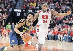  ?? [NATI HARNIK/THE ASSOCIATED PRESS] ?? Michigan’s David Dejulius tries to drive around Nebraska’s Yvan Ouedraogo during Tuesday’s game.