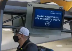  ?? Alyssa Pointer/ Atlanta Journal- Constituti­on ?? Delta Air Lines customers wear masks as they wait to be served at the ticket counter in the domestic terminal at Hartsfield- Jackson Atlanta Internatio­nal Airport on Friday.