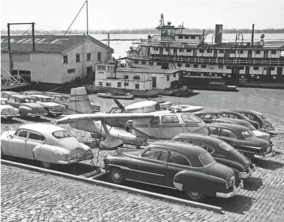  ?? THE COMMERCIAL APPEAL ?? A small amphibian cabin plane parked on the cobbleston­es at the foot of Union Avenue on March 19, 1952, wasn't competing with the autos for parking spaces. Owned by W.L. Gatz Jr., a cotton farmer from Paragould, Ark., it sank at anchorage on the Wolf River near Jefferson several nights ago, was raised and taken to the foot of Union to dry out. Mr. Gatz had flown to Memphis to attend a ginners meeting.