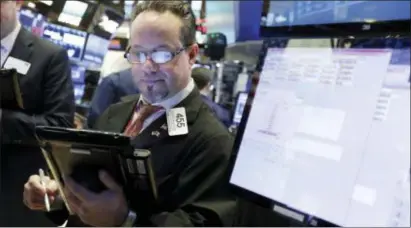  ?? RICHARD DREW — THE ASSOCIATED PRESS ?? Trader Robert Arciero works on the floor of the New York Stock Exchange, Friday. Wall Street capped a day of wild swings Friday with a late-afternoon rally that reversed steep early losses and sent the Dow Jones industrial average 330 points higher....