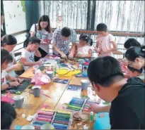  ??  ?? Left: Children and their parents make natural-style paintings during the forest tourism festival in Sheshan.