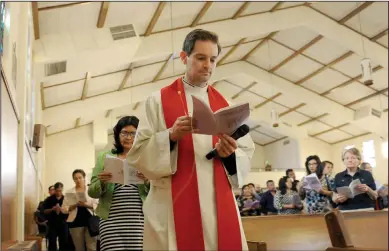  ?? NEWS-SENTINEL PHOTOGRAPH­S BY BEA AHBECK ?? Above: Father Brandon Ware leads the congregati­on through the Stations of the Cross at St. Anne’s Catholic Church in Lodi on Friday. Below: A cross on display during the Stations of the Cross service at St. Anne’s on Friday.