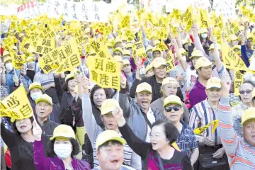  ?? — AFP photo ?? Fishermen and their families chant slogans during a demonstrat­ion outside the Agricultur­e Council in Taipei.