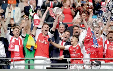  ?? — AP ?? Arsenal players celebrate their English FA Cup win over Chelsea at the Wembley Stadium in London on Saturday. Arsenal won 2-1.