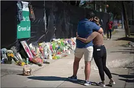  ?? ROBERT BUMSTED / AP ?? Two people who knew an unidentifi­ed victim of a fatal incident at the Houston Astroworld concert embrace at a memorial on Sunday.