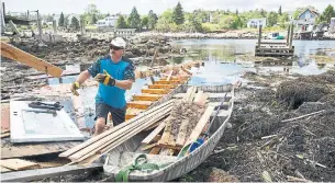  ?? ZANE WOODFORD STAR HALIFAX ?? Dan Duschesne empties debris from a boat in Herring Cove, N.S., Tuesday, after Dorian hit the area on Saturday. “The community’s taken a hard hit, there’s no doubt about it,” one resident said.