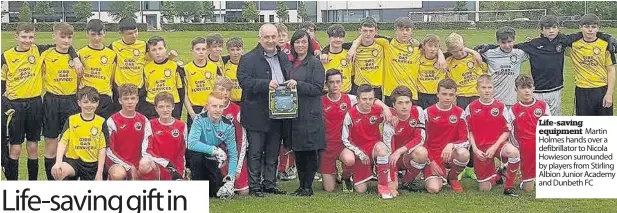  ??  ?? Life-saving equipment Martin Holmes hands over a defibrilla­tor to Nicola Howieson surrounded by players from Stirling Albion Junior Academy and Dunbeth FC