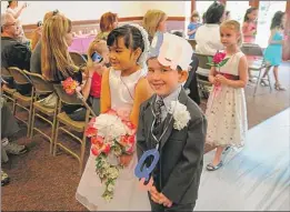  ?? | LARRY RUEHL~SUN-TIMES MEDIA ?? TOGETHER FOREVER: Erin Pascua and Mikey Horan at St. Linus School in Oak Lawn represente­d the letters Q and U at the marriage of these letters which are never apart.