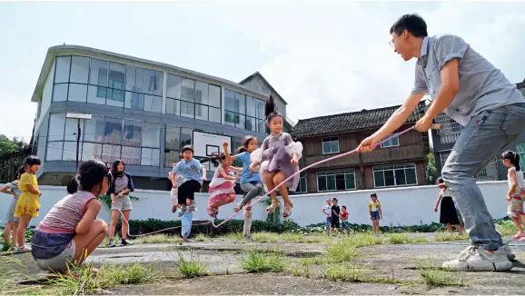  ??  ?? Le 17 juillet 2019, des étudiants bénévoles venant de l’Université de technologi­e et de commerce du Shandong donnent un cours d’éducation physique aux enfants, dans une école primaire située dans le village de Tongping, dans le district autonome dong de Tongdao, à Huaihua (Hunan).