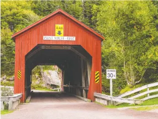  ??  ?? This red wooden covered bridge can be found on a remote road in New Brunswick’s Fundy National Park.