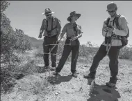  ??  ?? Wildlife ecologist Michael Vamstad, left, biologist Kristen Lalumiere and biologist Jeff Rangitsch stand by a desert tortoise burrow in Joshua Tree National Park.